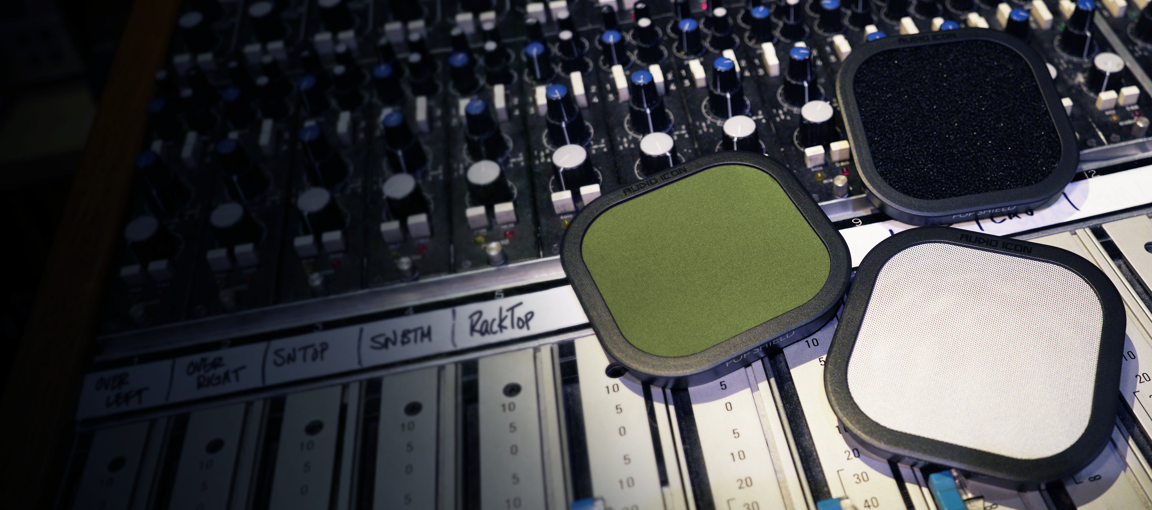 Three Pop Shield Pop filters on a mixing console. Foam, Metal, and Olive Green Pop Filter