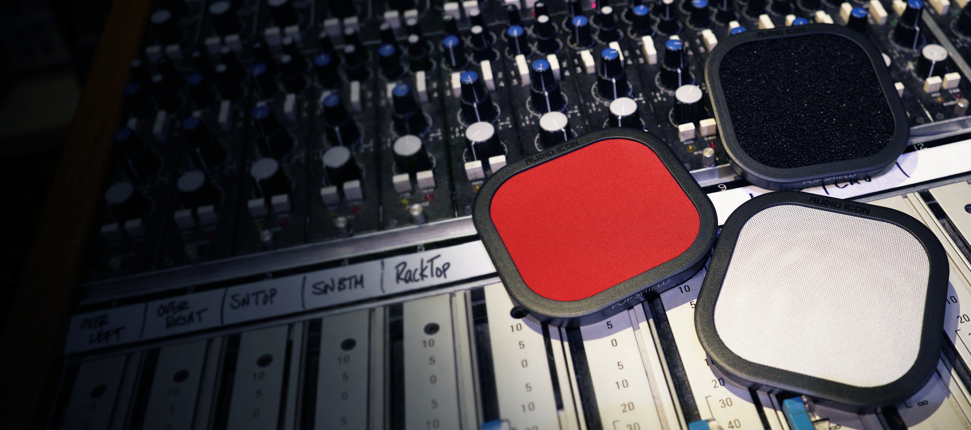Three Pop Shield Pop filters on a mixing console. Foam, Metal, and Red Pop Filter