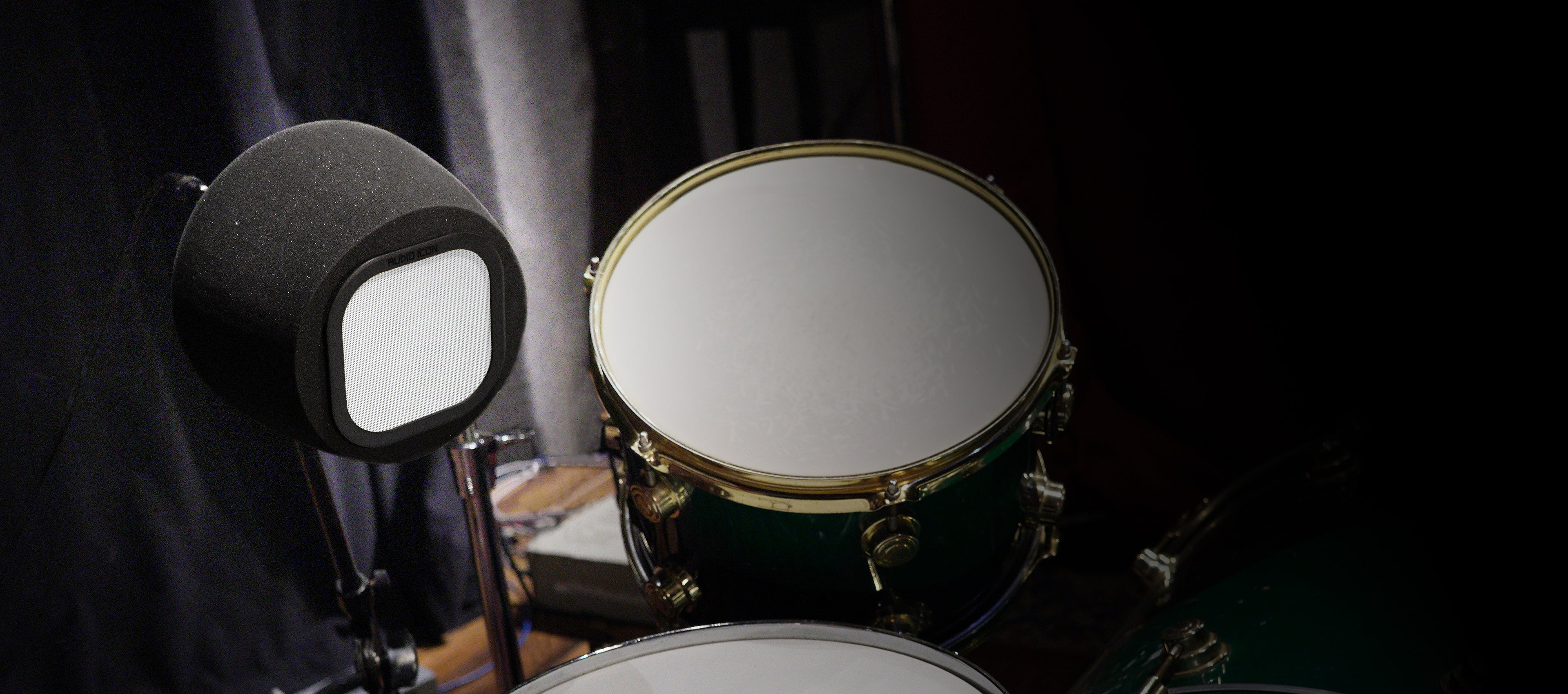Close-up of a drum set with the 7A iso booth on microphone on a dark background